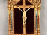 un cadre doré sur lequel est fixé un crucifix
