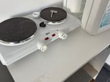 une cuisinière à deux feux sur laquelle est posée une bouteille de liquide