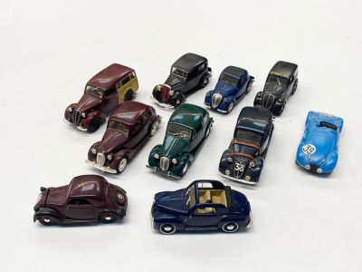 plusieurs petites voitures sont alignées sur une surface blanche