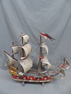 une maquette en bois d'un voilier posée sur un socle