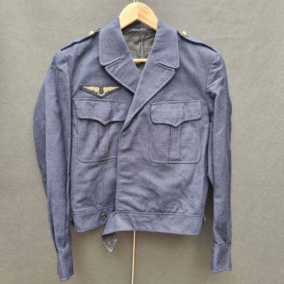 a blue jacket hanging on a hanger on a wall