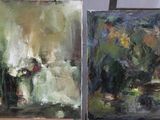 two paintings that are on a easel on a table