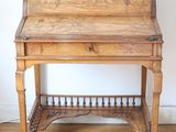 a small wooden desk with a drawer on top of it