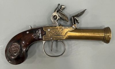 gros plan d'un pistolet sur une surface blanche