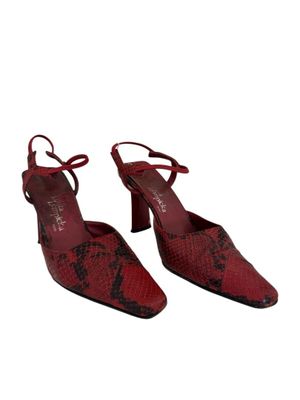 une paire de chaussures en peau de serpent rouge sur fond blanc