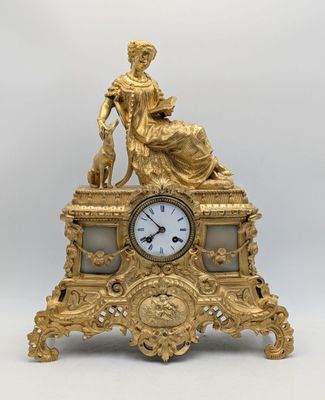 l'image d'une horloge en or sur laquelle est assise une femme