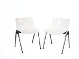 une paire de chaises en plastique blanc avec des pieds en métal, sur fond blanc