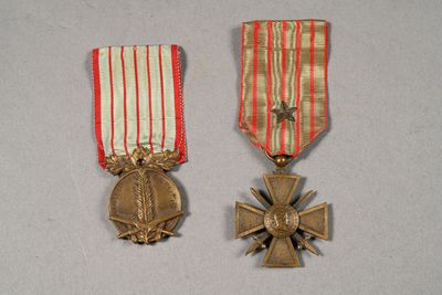 two medals and a cross on a white surface