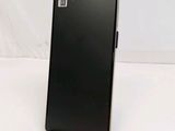 the back of a black cell phone sitting on top of a white table