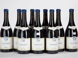 six bouteilles de vin sont alignées sur une surface blanche