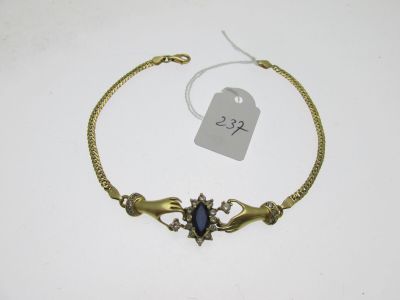 un bracelet en or orné d'une pierre bleue au centre