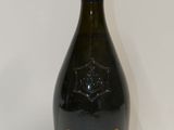 la bouteille de champagne est posée sur une surface blanche