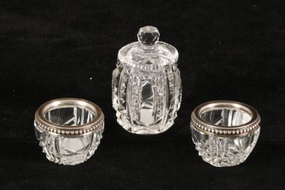three pieces of glass on a black surface with a silver lid