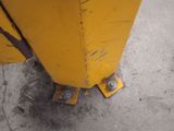 a close up of a yellow pole on the sidewalk