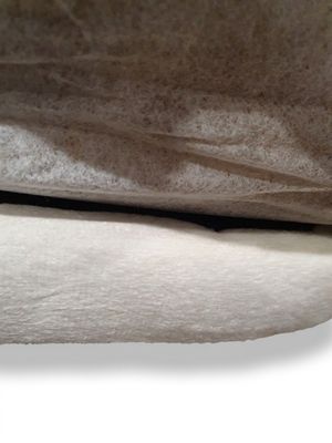un chat allongé sur un lit, sous une couverture