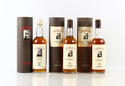 trois bouteilles de whisky sont alignées sur une surface blanche