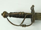 a close up of a sword on a white surface
