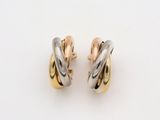 a pair of gold and silver earrings on a white background