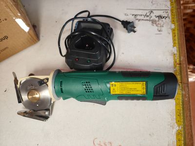 a green and black electric tool sitting on a table