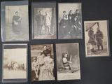 several old black and white photographs of men and women on a wall