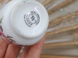 a person holding a bottle of nail polish in front of a fan