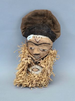 une image représentant un masque en bois surmonté d'un chapeau