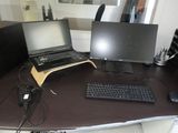 a desk with two computers and a keyboard on it
