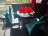 brightly colored chairs and a table in a room with a balcony