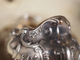 a silver vase with an elephant on it sitting on a table