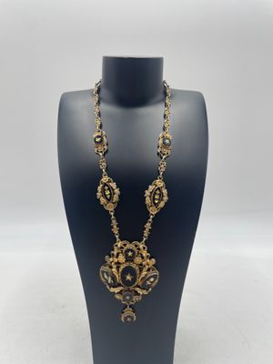 un mannequin noir portant un collier noir et doré