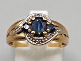 a close up of a gold ring with a blue sapphire stone