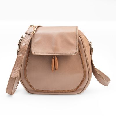 a tan leather cross body bag with a tassel on the front