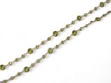 collier avec des pierres vertes et une chaîne en argent sur fond blanc