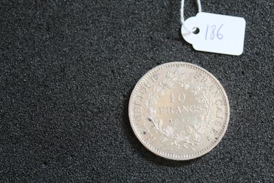 une pièce d'argent posée sur une surface noire, avec une étiquette de prix