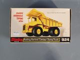the box of a yellow toy dump truck is sitting on the table