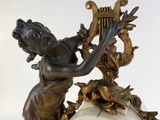 a statue of a woman holding a clock on a table
