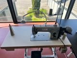 a sewing machine sitting on a table in front of a window