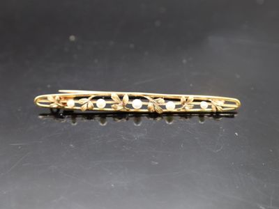 un gros plan d'une barrette dorée ornée de perles