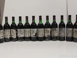several bottles of wine are lined up on a white table