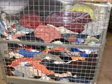 a cart with a lot of clothes on it in a warehouse