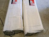 two rolls of fabric on the floor next to each other