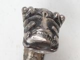 a small metal animal head on top of a cane