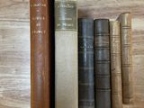 de nombreux livres posés sur la table, les uns empilés sur les autres