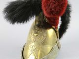 a gold shoe with a red pom pom on top of it
