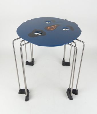 une petite table bleue à quatre pieds, sur laquelle se trouve une horloge