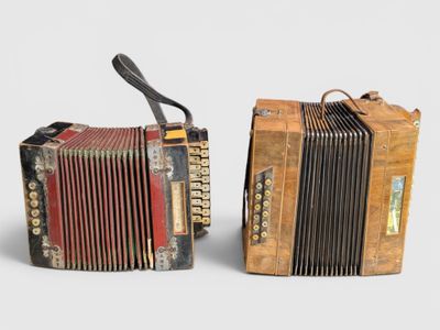 pair of old accordions with leather straps on each side of them