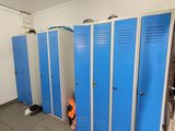Plusieurs casiers bleus sont alignés les uns à côté des autres dans une salle de bains