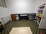 a room with a table, bookshelf, and a bookcase