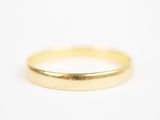 gros plan d'une bague en or sur une surface blanche