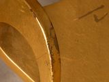 gold metal chair with a curved back and a curved seat
